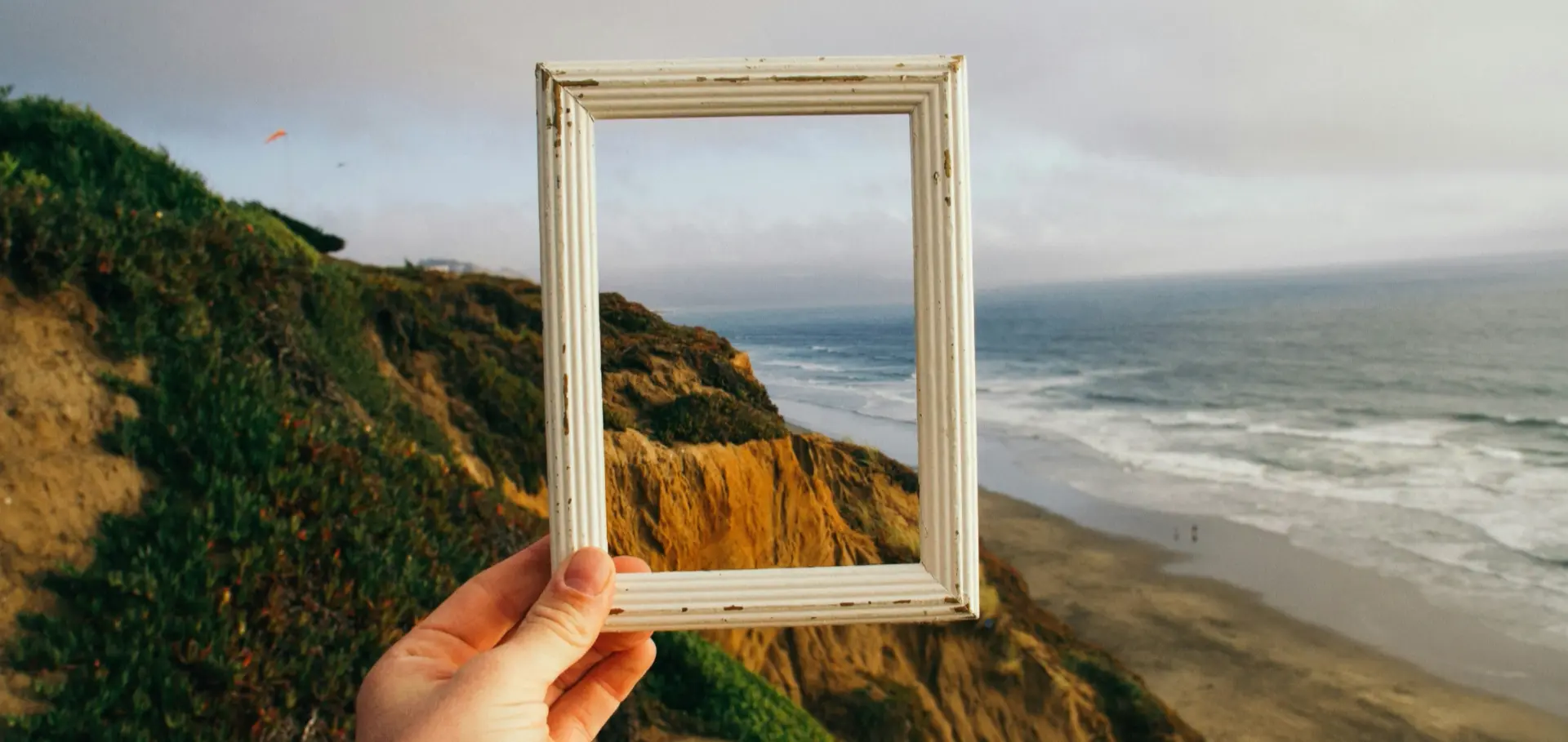 A frame held up against a coastline
